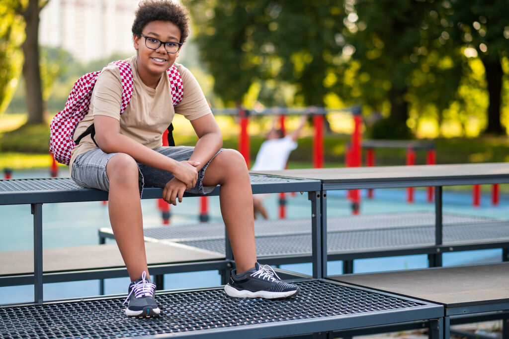 African american teen sitting at the playground after school